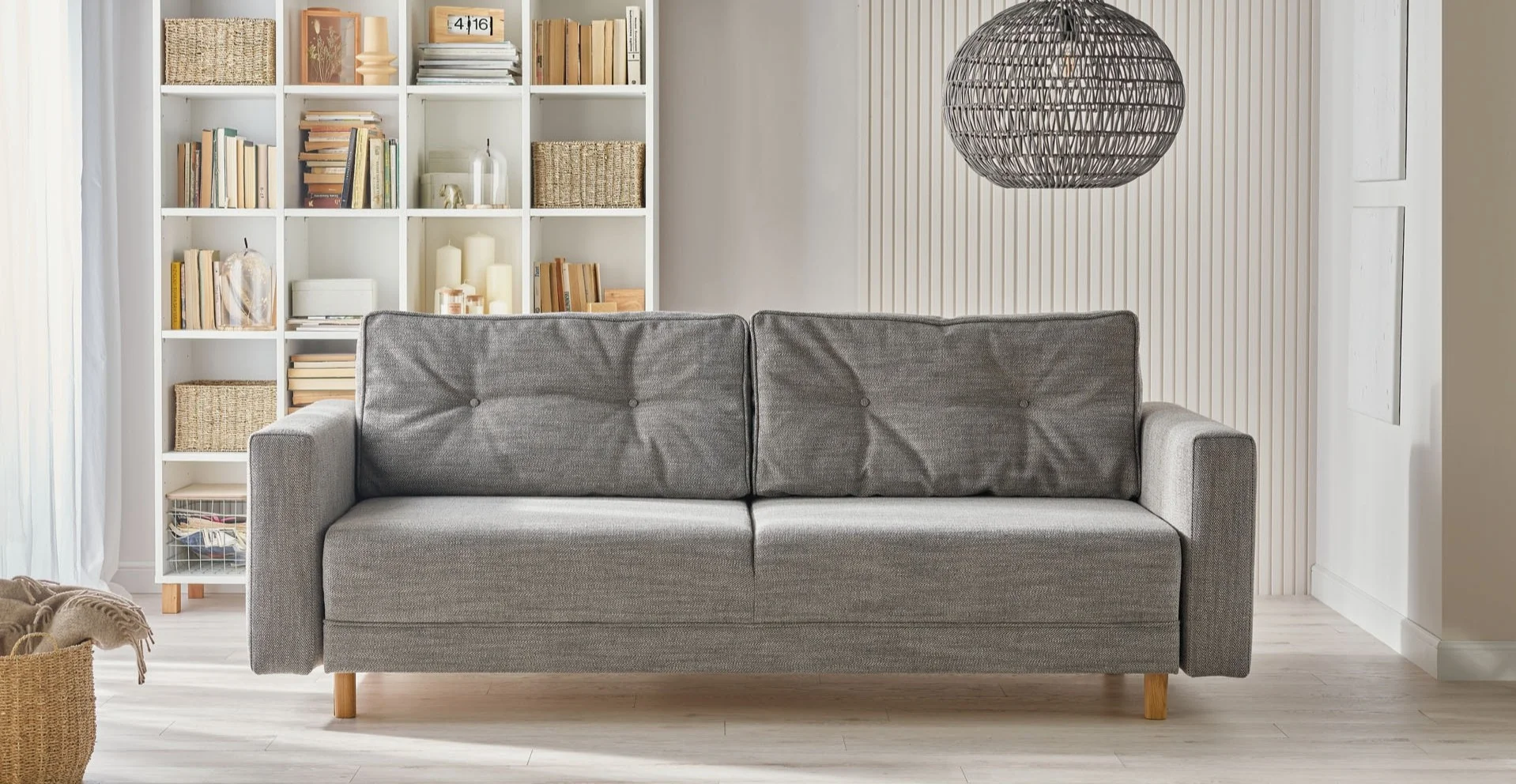 Szafa sofa z podłokietnikami na tle białej ściany